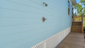 Paredes externas em azul claro, com uma porta de metal e uma janela.
