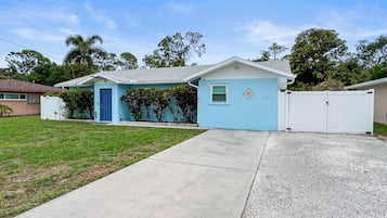 A single-story house with a blue exterior, a front door, and a small window.