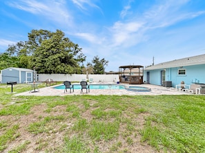 A backyard with a swimming pool, a gazebo, and a small shed. - Azure Bungalow: Pool, Gazebo, & Beach Vibes, A/C, 15 mins from Anna Maria Island (Bradenton)
