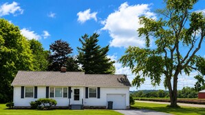A single-story house with a front porch, a small front yard, and a tree to the right. - Olivet Cottage, Sleeps 14, Family Friendly Retreat Minutes from Paducah (Paducah)