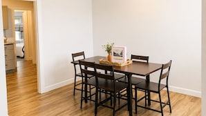 A dining area with a table and chairs, a vase with a plant, and a framed picture on the table. - Olivet Cottage, Sleeps 14, Family Friendly Retreat Minutes from Paducah (Paducah)