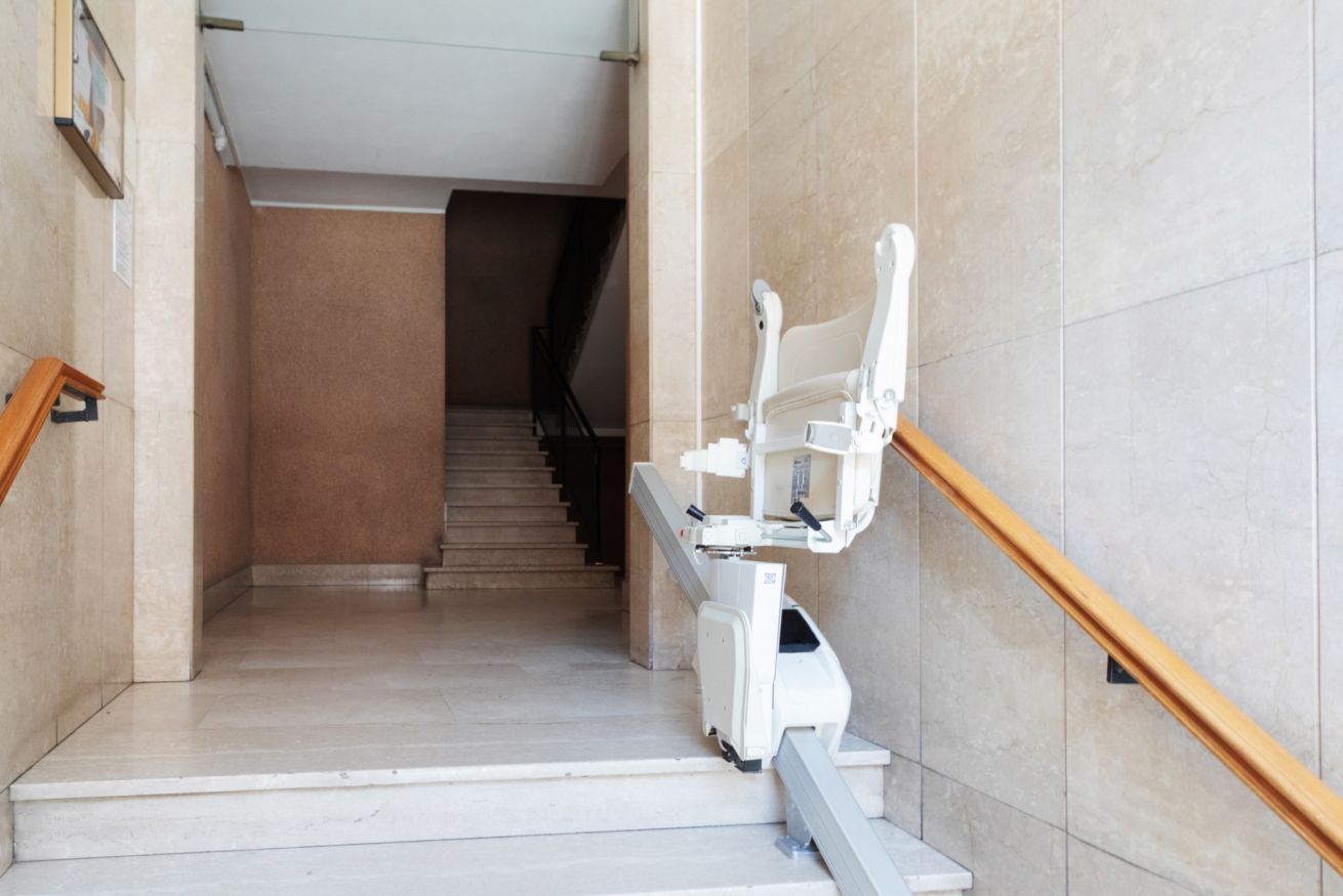 Een trap met een wit toilet en een leuning aan de rechterkant.