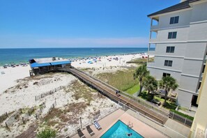 A beach view with a pool and a building with multiple floors. - Boardwalk 486 (Gulf Shores)