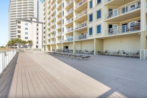 Ein mehrstöckiges Hotel mit Balkonen, einer überdachten Außenbereich-Sitzgelegenheit und einem Holzboden.