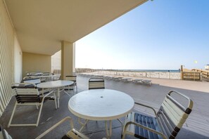 A covered outdoor area with tables and chairs, overlooking a beach. - Boardwalk 486 (Gulf Shores)