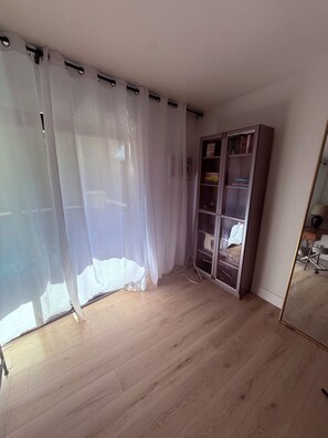 A room with a wooden floor, a bookshelf, and a large mirror. - Cozy 1-bedroom apartment in welcoming Winnetka with AC (Winnetka)