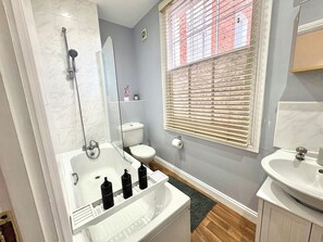 A bathroom with a glass-enclosed shower, a toilet, a sink, and a window with blinds. - Spacious Townhouse central Leamington with parking (Royal Leamington Spa)