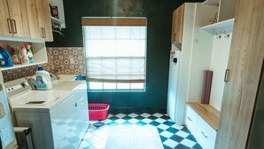 A compact kitchen with a checkered floor, wooden cabinets, a window, and a refrigerator. - Wayfarer Basecamp-Centrally located. RC track! (Orlando)