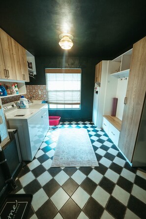 A compact kitchen with a checkered floor, wooden cabinets, a window, and a refrigerator. - Wayfarer Basecamp-Centrally located. RC track! (Orlando)