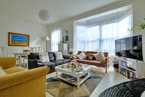 Ein Wohnzimmer mit Sofa, Couchtisch und Fernseher.