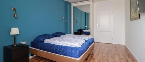 2 habitaciones, tabla de planchar con plancha y muebles diferentes