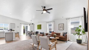 A spacious living area with a sofa, chairs, a coffee table, and a ceiling fan. - Curated Comfort in the Treasure Valley (Boise)