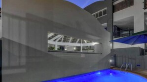 Une piscine avec vue sur un immeuble doté de balcons.