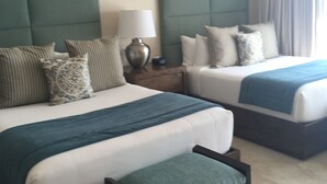 A hotel room with two beds, a nightstand, a lamp, and a window with curtains. - Posh 2-bedroom condo in charming Cabo with AC, kitchen and 2.5 baths.Ocean view. (Cabo San Lucas)