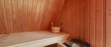 Un sauna avec des murs en bois et un banc.