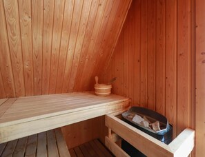 Una sauna con pareti in legno e una panchina.