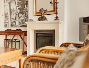Una habitación con chimenea, un espejo y una mesa de madera.