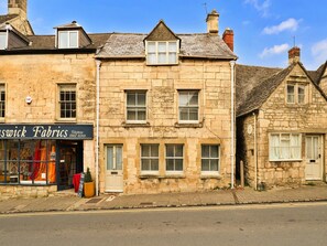 A stone building with a shop on the ground floor named 'Aswick Fabrics.' - Luxury Stone Painswick Retreat for 6 (Stroud)