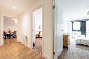 Eine moderne Wohnung mit Essbereich, Schlafzimmer und Blick auf die Stadt.