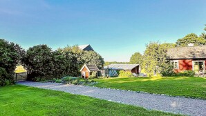 A rural property with a gravel path, a red barn, and a small wooden structure. - 4 Star Holiday Home in Osthammar (Osthammar)