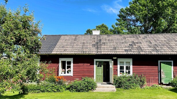 A red wooden house with a green door, white windows, and a tiled roof. - 4 Star Holiday Home in Osthammar (Osthammar)