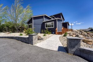 A modern two-story house with a stone pathway leading to the entrance, surrounded by a landscaped garden with rocks and trees. - Reno Retreat - 3BR Oasis w Swim Spa, Hot Tub (Reno)