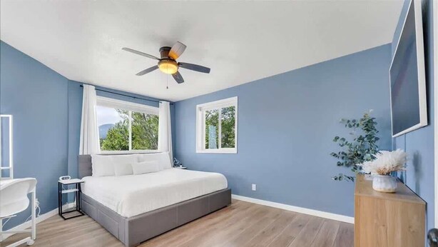 A bedroom with a bed, a desk, a chair, a ceiling fan, and a window. - Reno Retreat - 3BR Oasis w Swim Spa, Hot Tub (Reno)