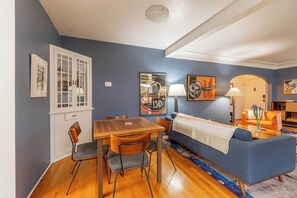 A room with a dining table, chairs, a sofa, and artwork on the walls. - The Luxury Brick Home Mature Yard Chef Kitchen (Reno)