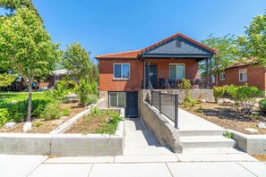 A two-story brick house with a balcony, a front door, and a small porch. - Cozy Reno Studio Near Hot Spots (Reno)