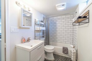 A bathroom with a white sink, a toilet, and a shower area. - Cozy Reno Studio Near Hot Spots (Reno)