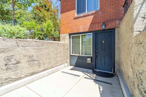 A residential building with a brick facade, a dark-colored entrance door, and a small window above the door. - Cozy Reno Studio Near Hot Spots (Reno)