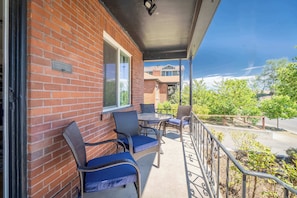 A brick building with a balcony featuring wicker chairs and a table. - Midtown Sanctuary w Pac-man! (Reno)