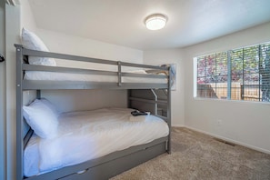 A bunk bed room with a window, carpeted floor, and a ceiling light. - Large Group Escape, 5 Beds, Pets Welcome (Reno)