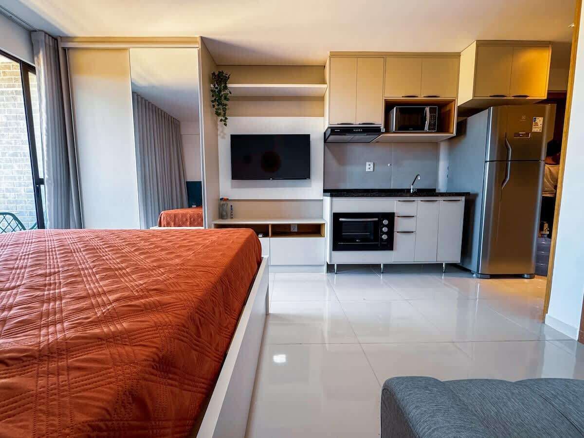 Ein Hotelzimmer mit Bett, Küchenzeile und Fernseher.