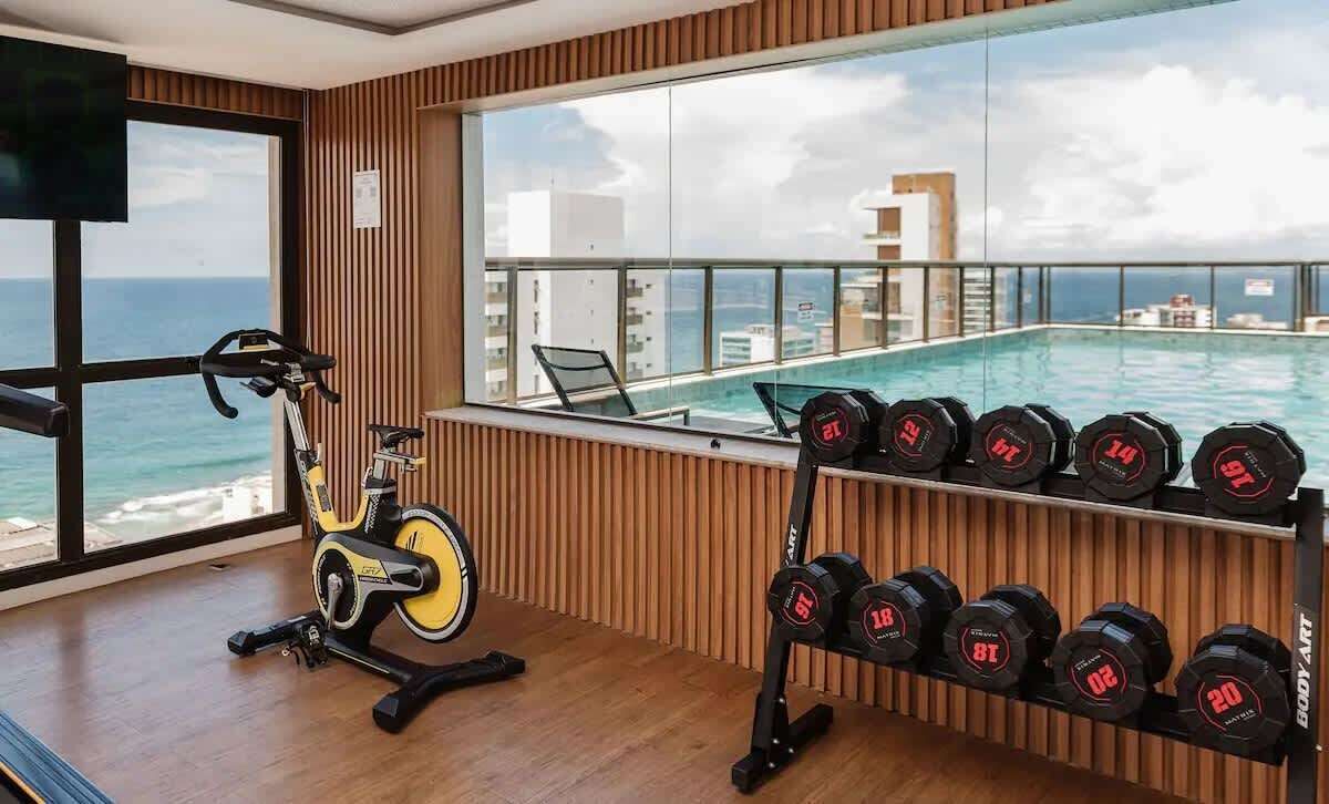 Un gimnasio con equipo de ejercicio, una bicicleta y un soporte para pesas con lastres.