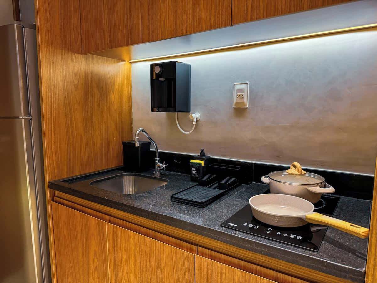 A compact kitchen with a sink, a stove, and a countertop.