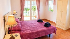 A bedroom with a bed, a nightstand, a lamp, a wardrobe, and a view of the outdoors. - Villa La Vida Antas by Ruralidays (Almería)