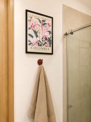 A framed picture of a flower market with a towel hanging below it. -   Luxury Beach Apartment, Master Suite + Office, Walk to the Beach (Cartagena)
