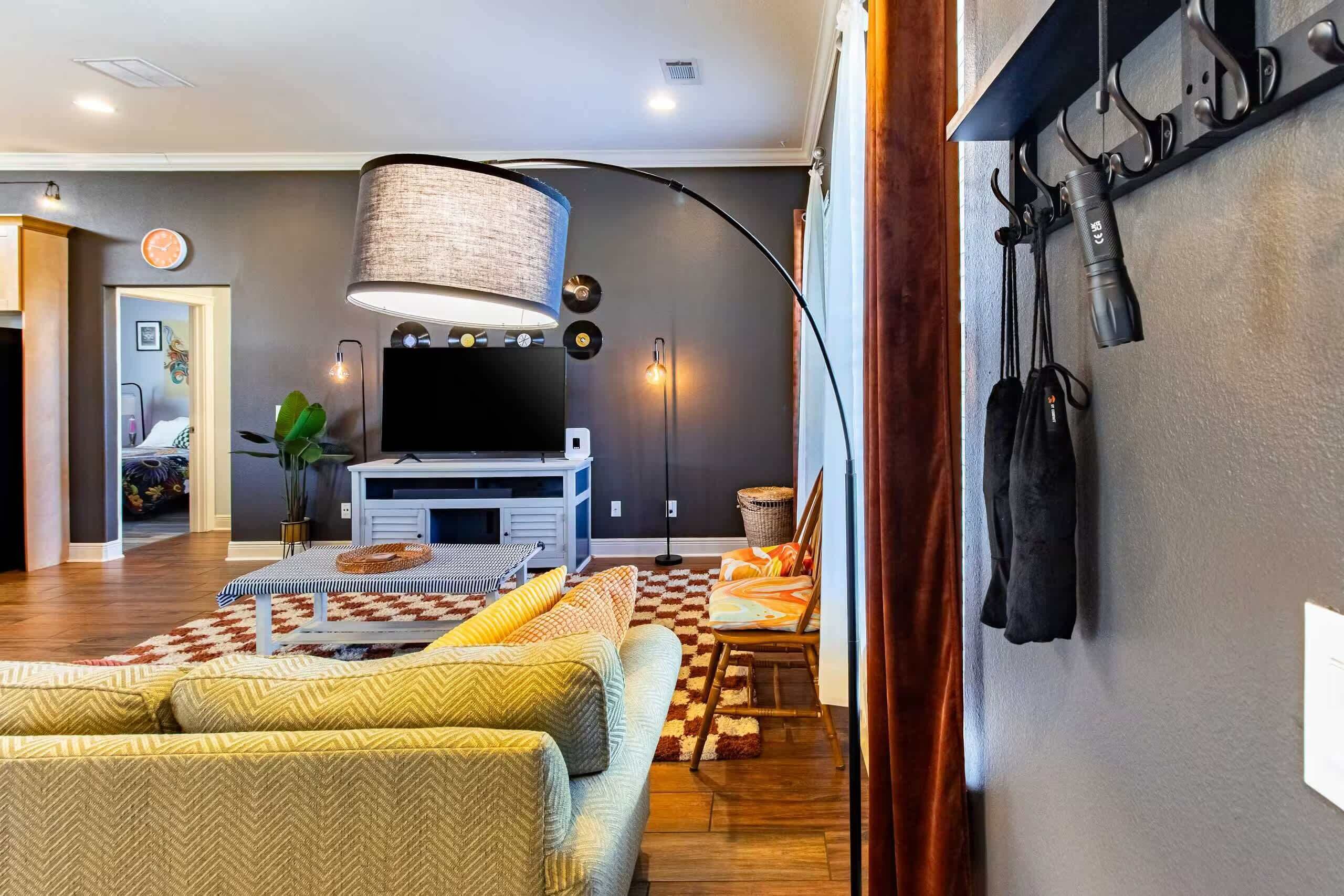 Een moderne woonkamer met een flatscreen televisie, een grote lamp en een zithoek met een kamerbreed tapijt.