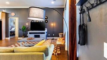 Een moderne woonkamer met een flatscreen televisie, een grote lamp en een zithoek met een kamerbreed tapijt.