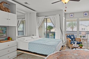 A bedroom with a bed, a dresser, a chair, and a balcony with a view. - Sandpiper Cove Unit 8248 Pet-Friendly | 3-minute walk to the beach (Destin)