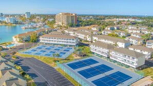 Et kysthotel med flere etager, en tennisbane og en lysthavn.