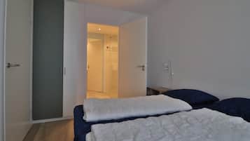 2 habitaciones, tabla de planchar con plancha y muebles diferentes