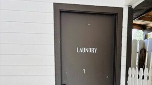 Una porta con la scritta 'LAUNDRY' e un recinto in legno bianco sullo sfondo.