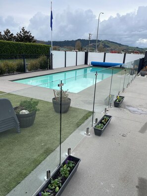 Une piscine avec vue sur un plan d’eau et des collines au loin.