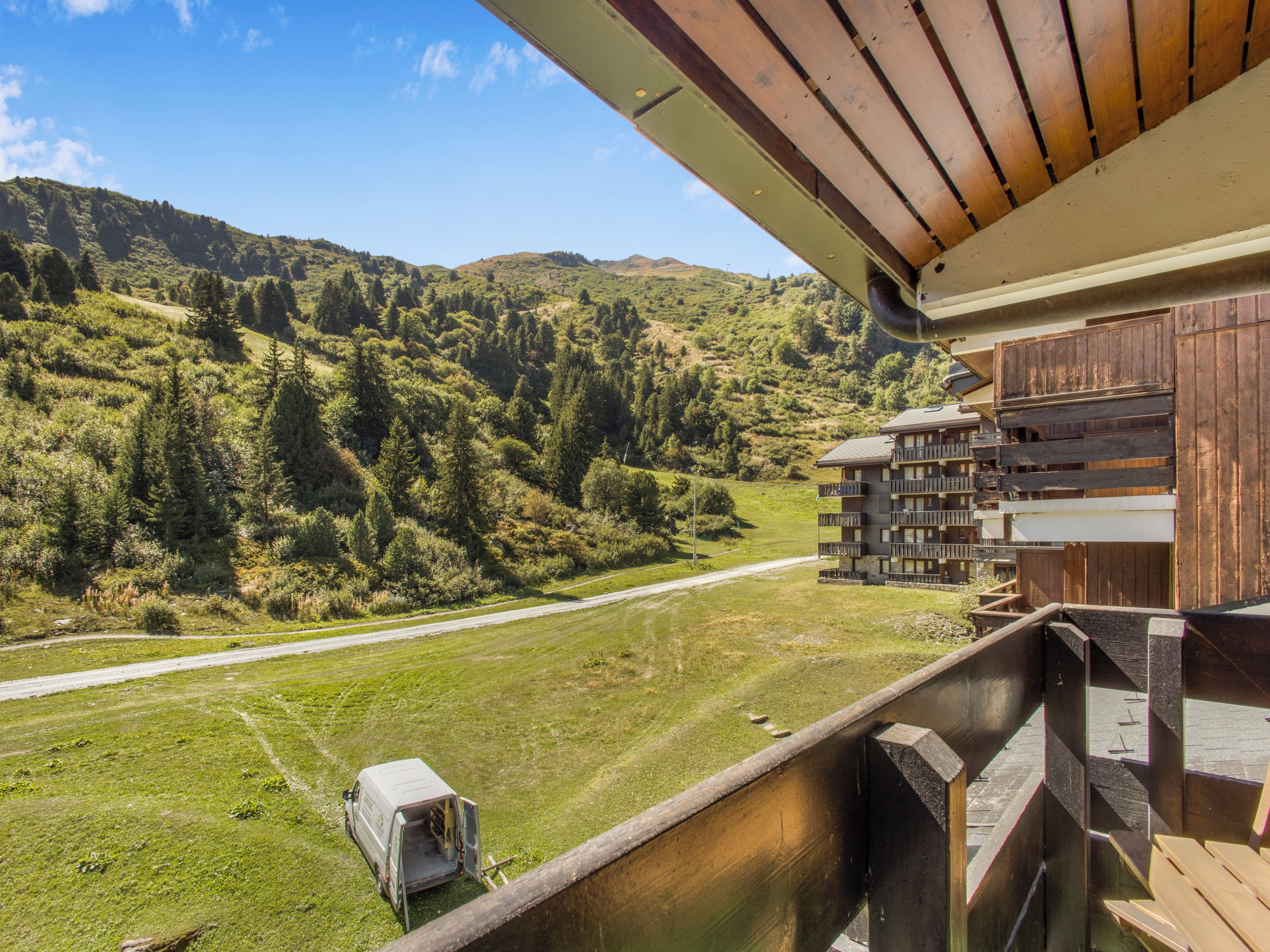A mountain view from a wooden balcony with a clear sky.