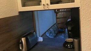 Ett litet, praktiskt kök med en brödrost, en kaffebryggare och ett litet kylskåp.