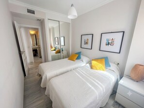 Ein Schlafzimmer mit zwei Betten, einem Spiegel und Bildern an der Wand.