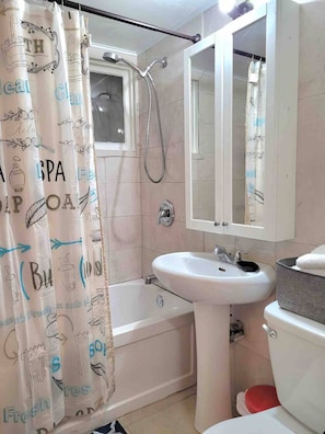 Ein Badezimmer mit Badewanne, Waschbecken, Toilette und einer Duschvorhang mit Text und Illustrationen.