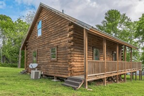 A log cabin with a porch and a satellite dish.